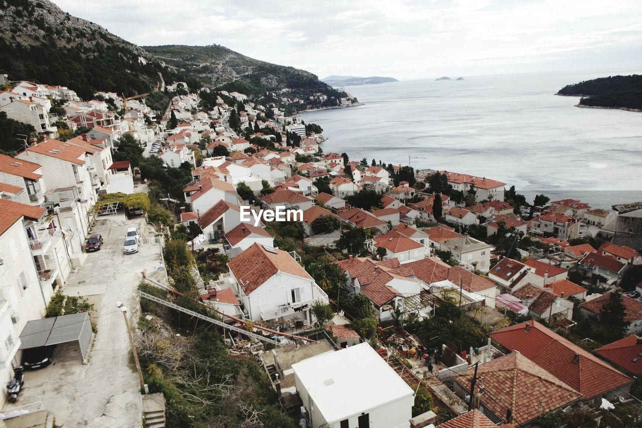 High angle view of townscape by sea against sky