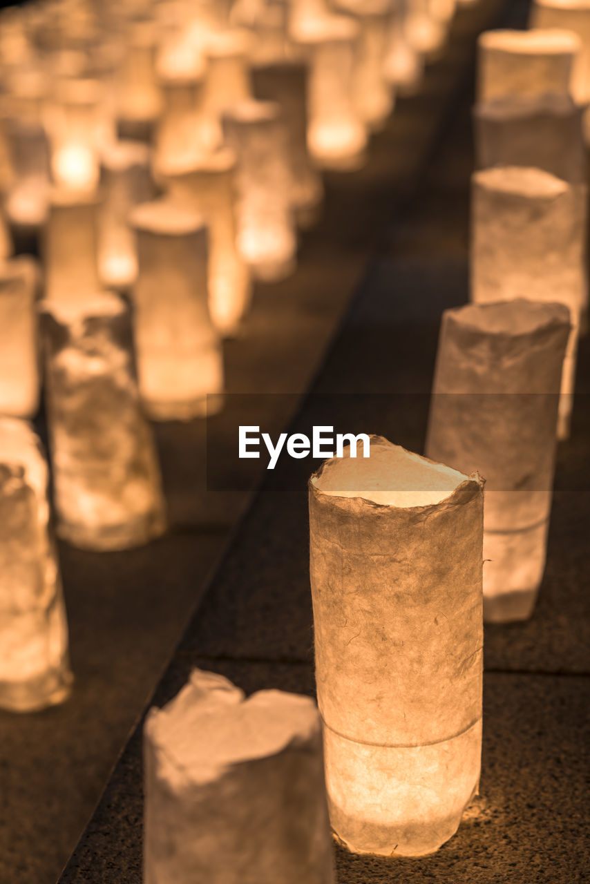 CLOSE-UP OF ILLUMINATED LAMP IN ROW AT TEMPLE