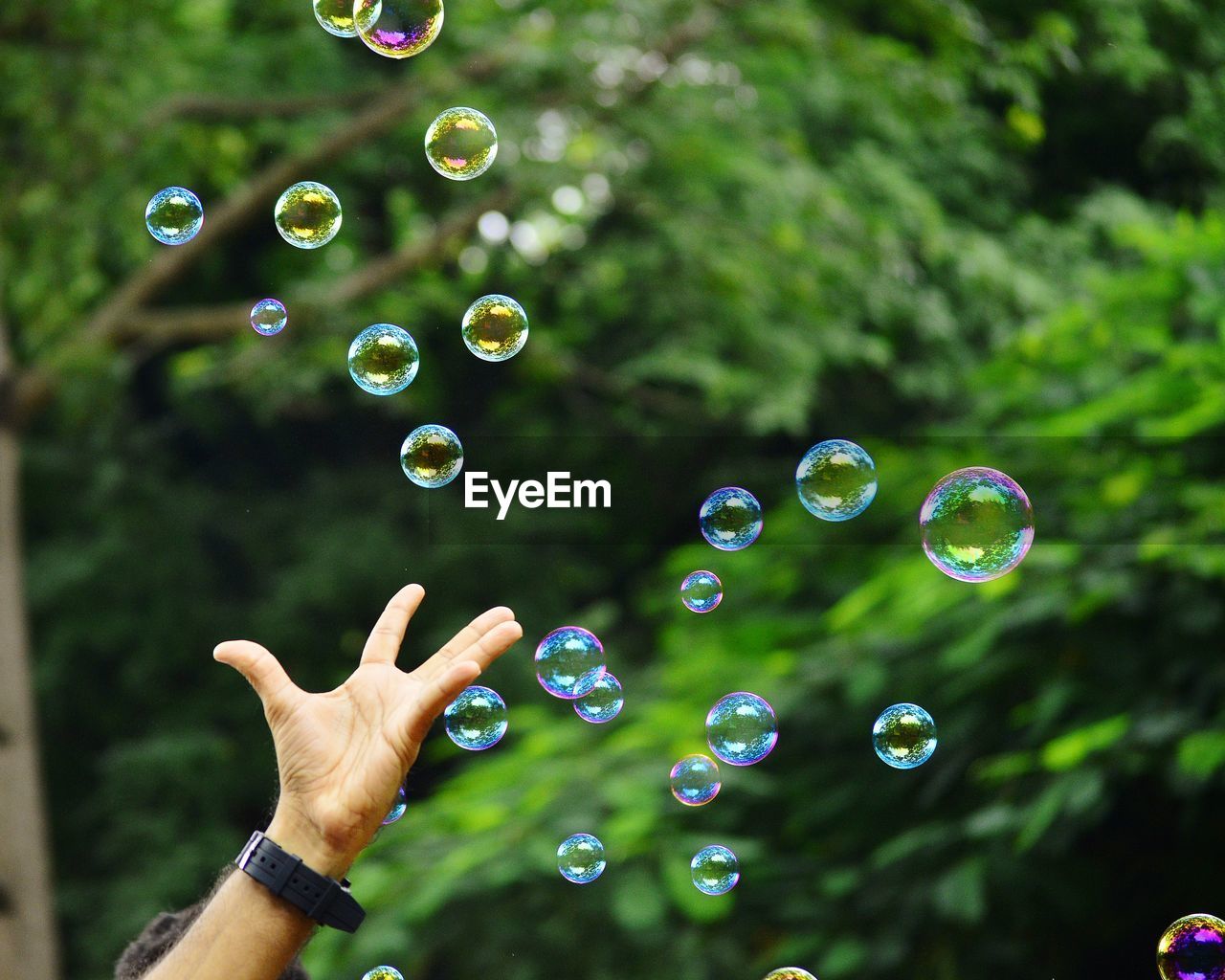 Close-up hand amidst bubbles