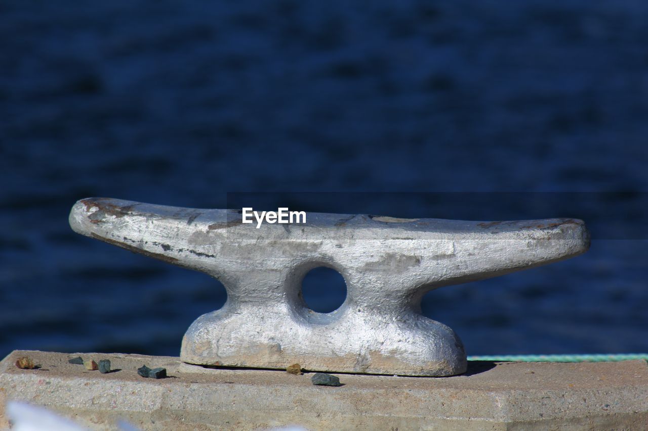 Close-up of metallic bollard at harbor