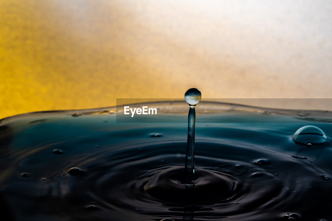 CLOSE-UP OF WATER DROP FALLING FROM SURFACE