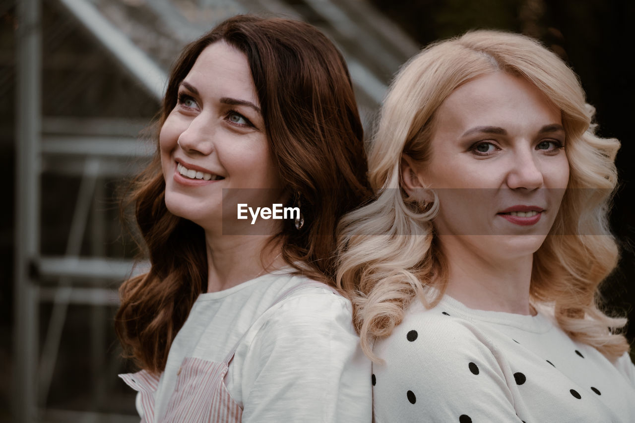 Two mature sisters in the garden in the evening. portrait of woman at her 40s and 30s, relatives