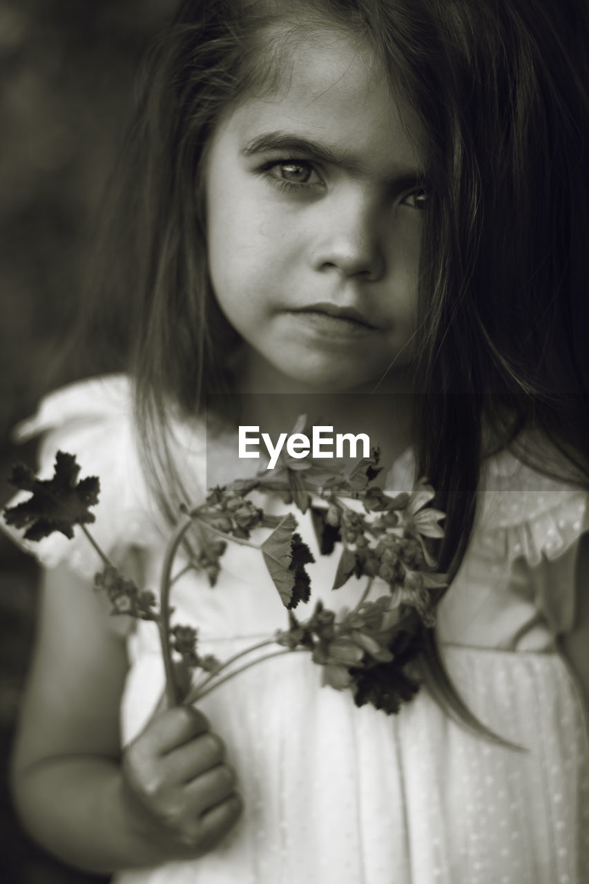 Portrait of cute girl holding flower