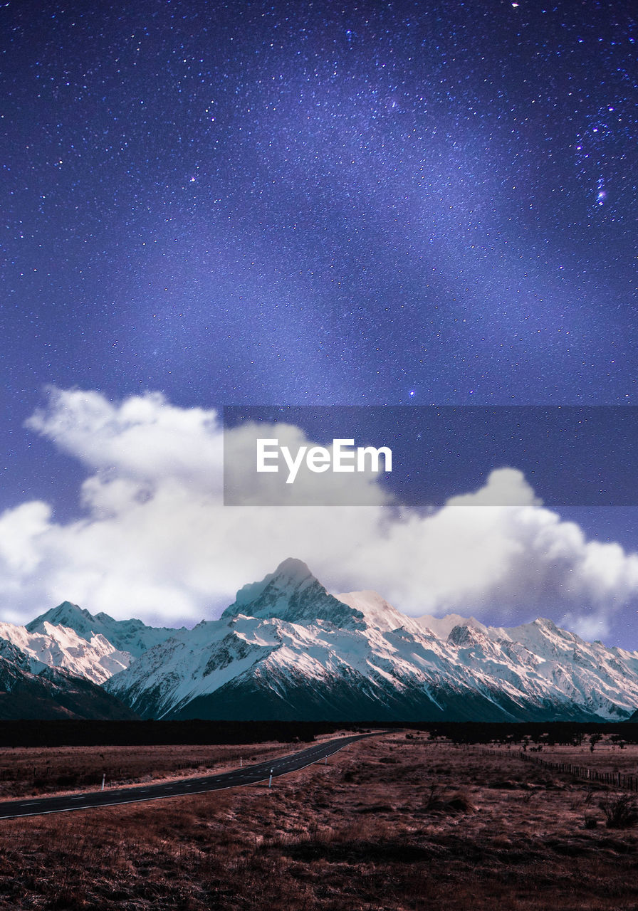 Scenic view of snowcapped mountains against sky at night