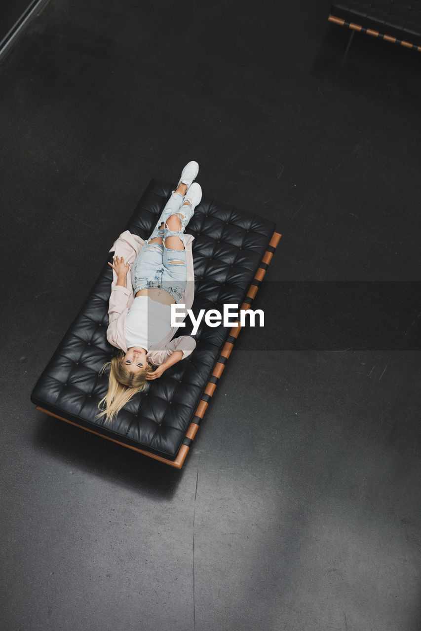 High angle portrait of woman lying on mattress