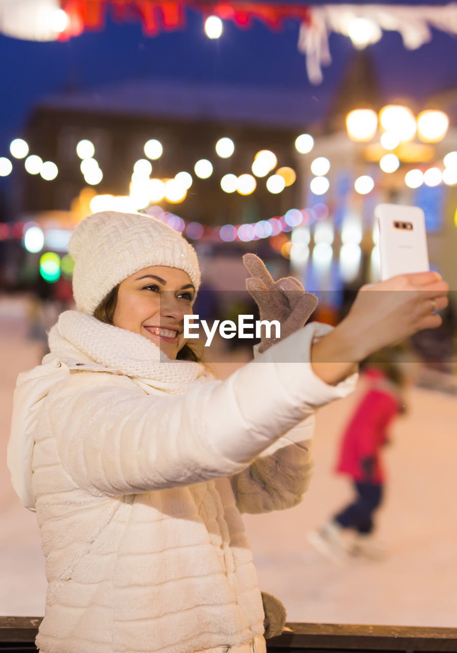 portrait of smiling young woman using mobile phone