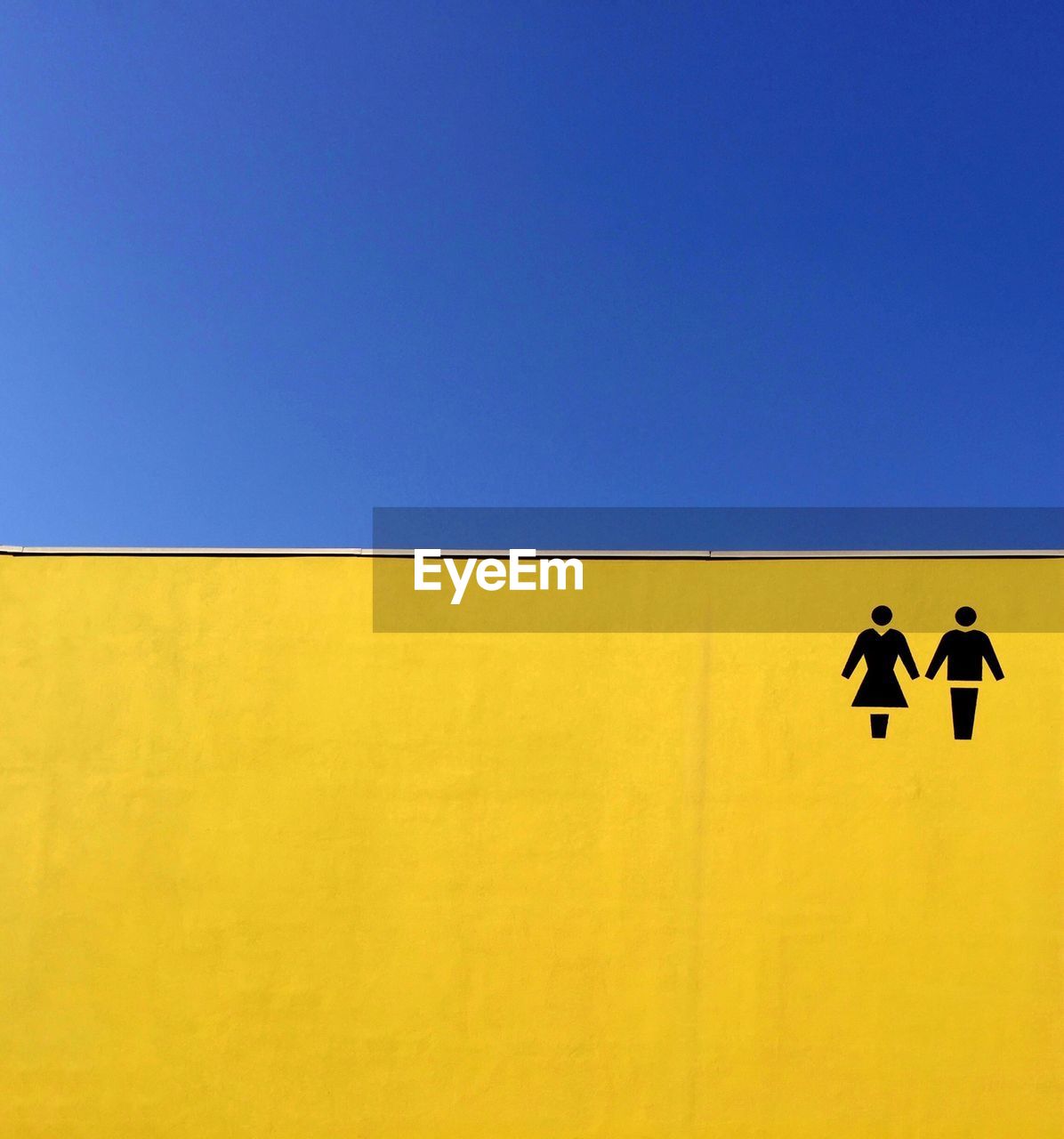 Close-up of human representation on yellow wall