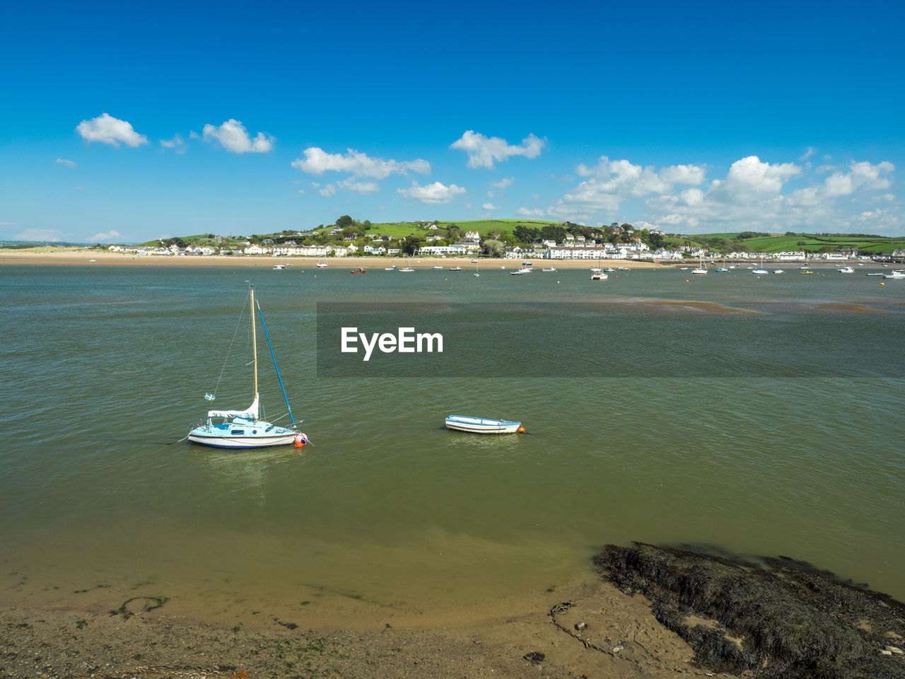 Sailboats moored on sea against sky