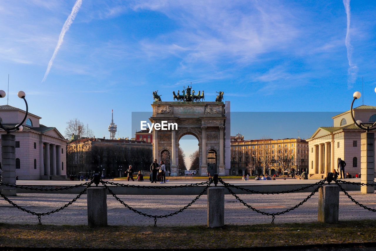 View of gate in city against cloudy sky