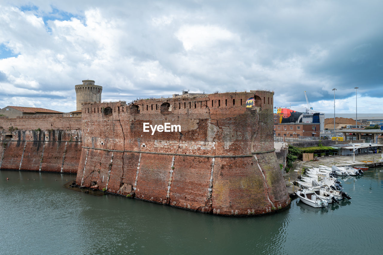 VIEW OF BUILDINGS AGAINST CLOUDY SKY IN SEA