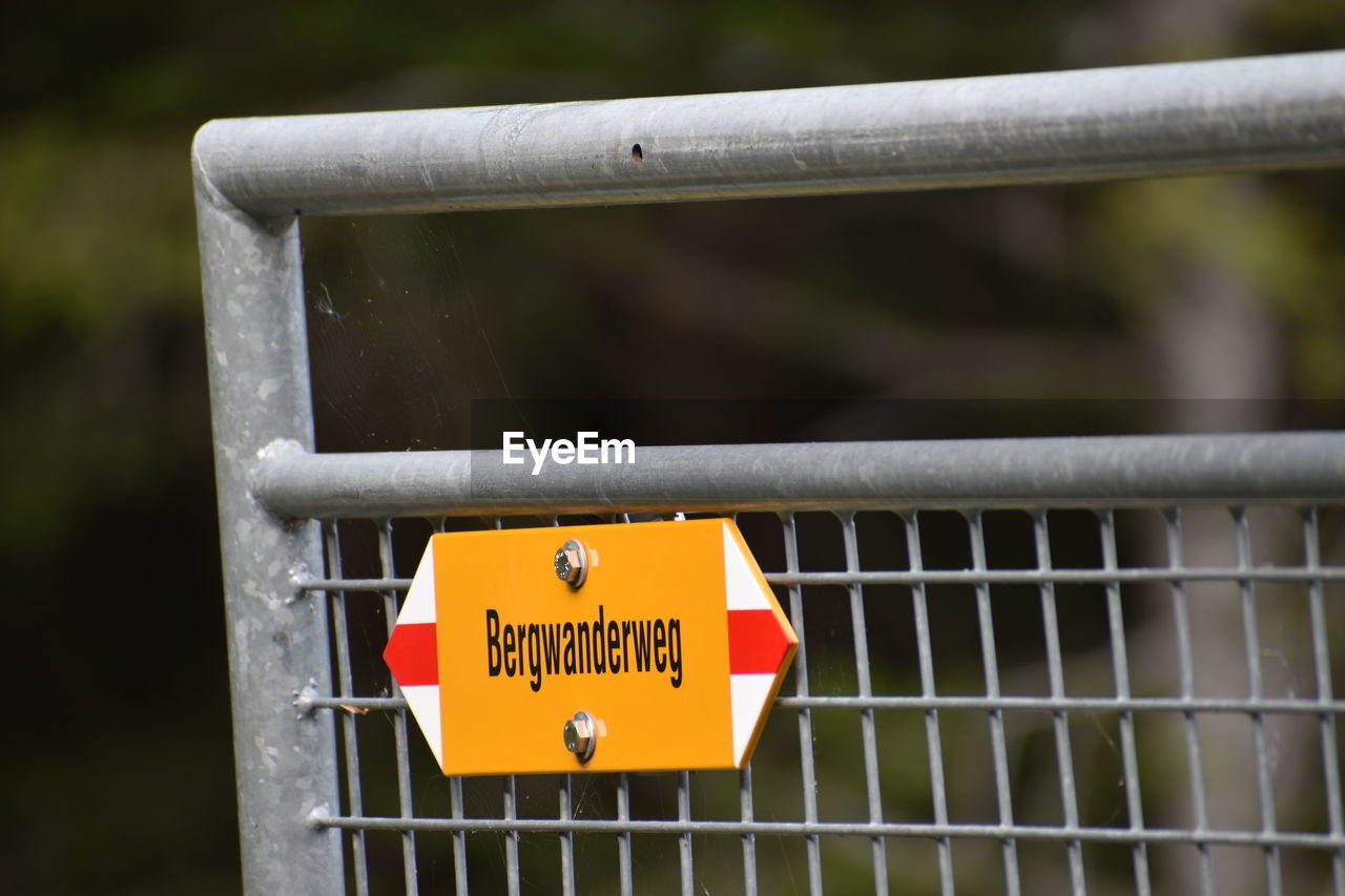 communication, yellow, text, sign, metal, focus on foreground, green, no people, western script, protection, security, close-up, warning sign, fence, outdoors, day, nature, forbidden