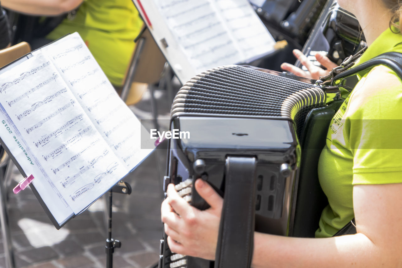 Midsection of woman playing accordion