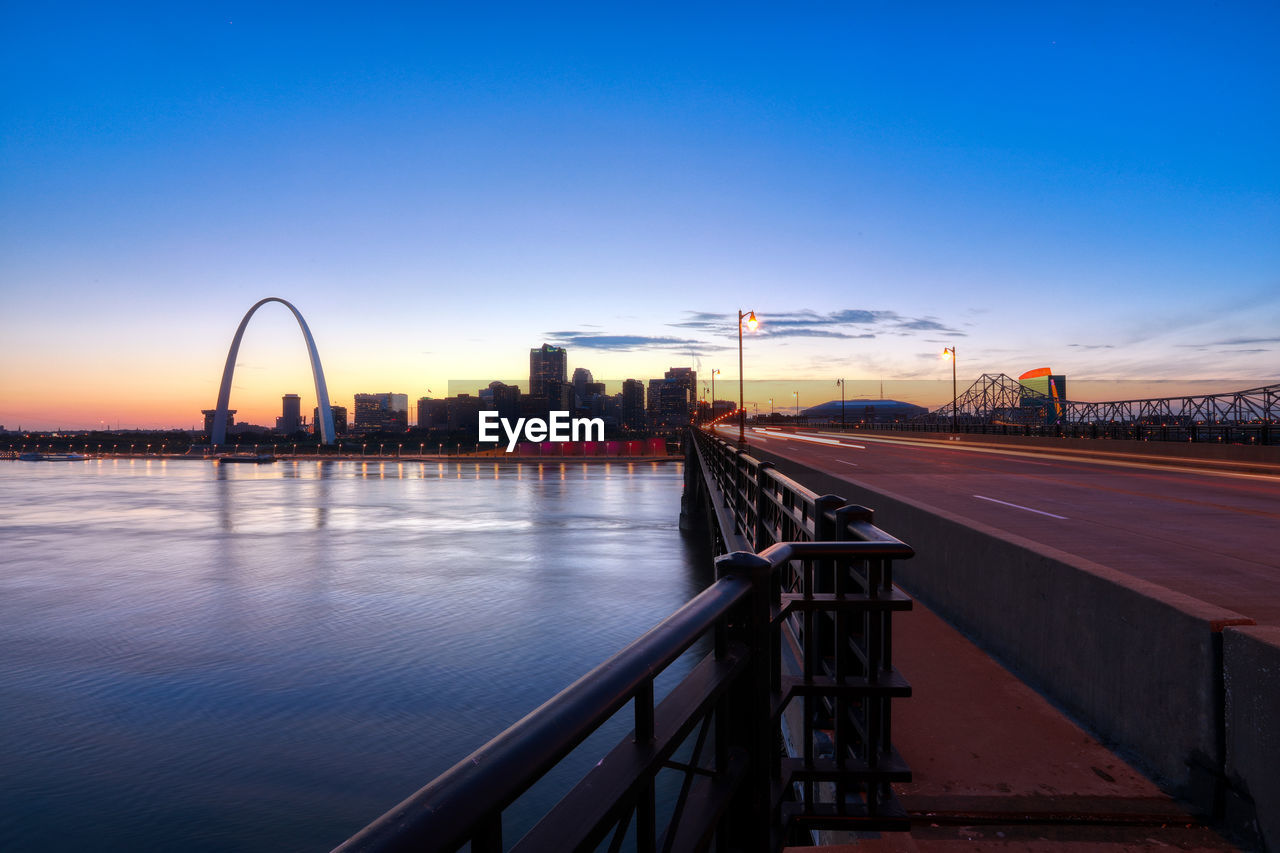 VIEW OF BRIDGE OVER RIVER AT SUNSET