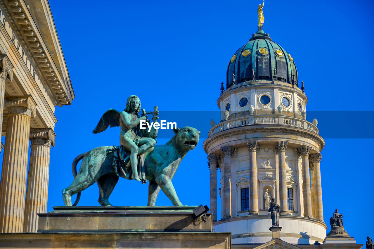 LOW ANGLE VIEW OF STATUE AGAINST BUILDINGS