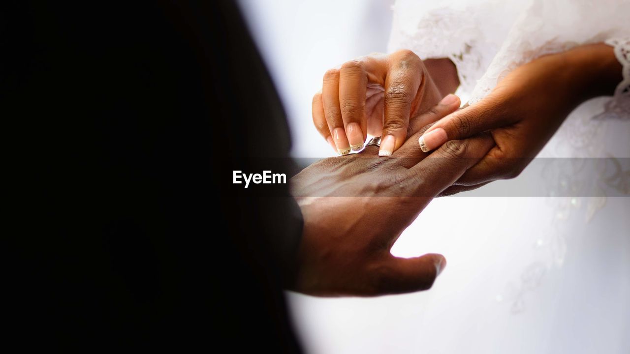 Cropped hand of couple exchanging wedding ring