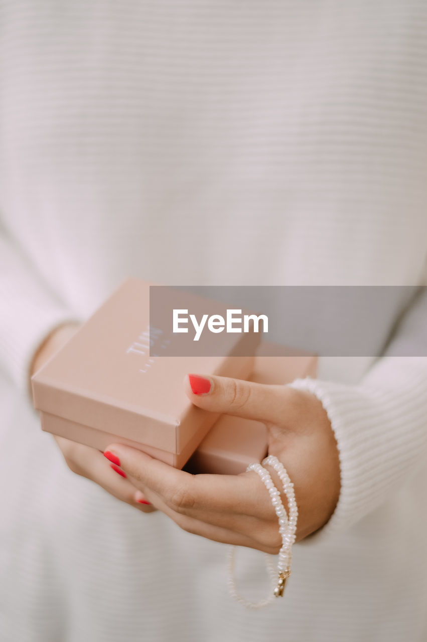 CLOSE-UP OF WOMAN HAND HOLDING PAPER