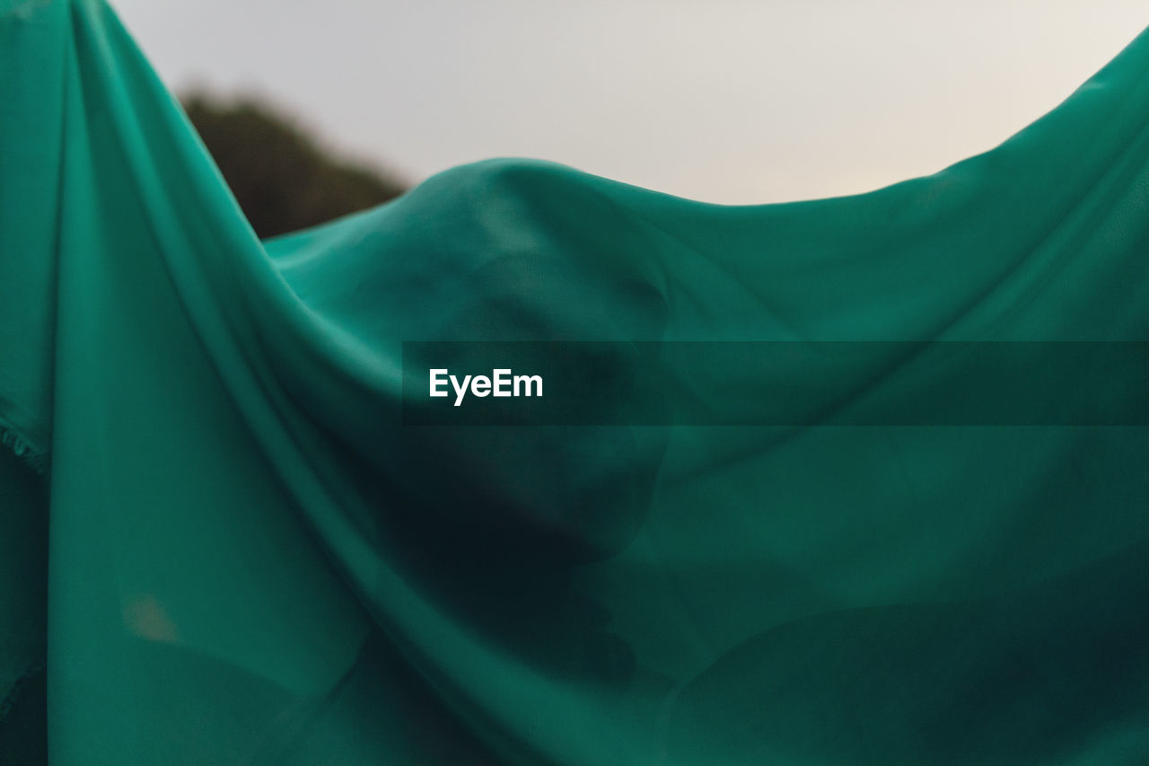 Close-up of woman with face covered by green scarf