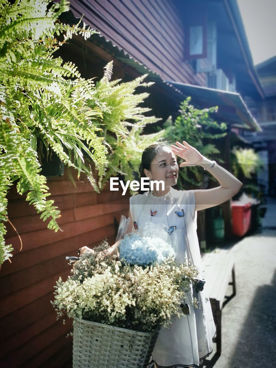 Woman with flower bouquet against building