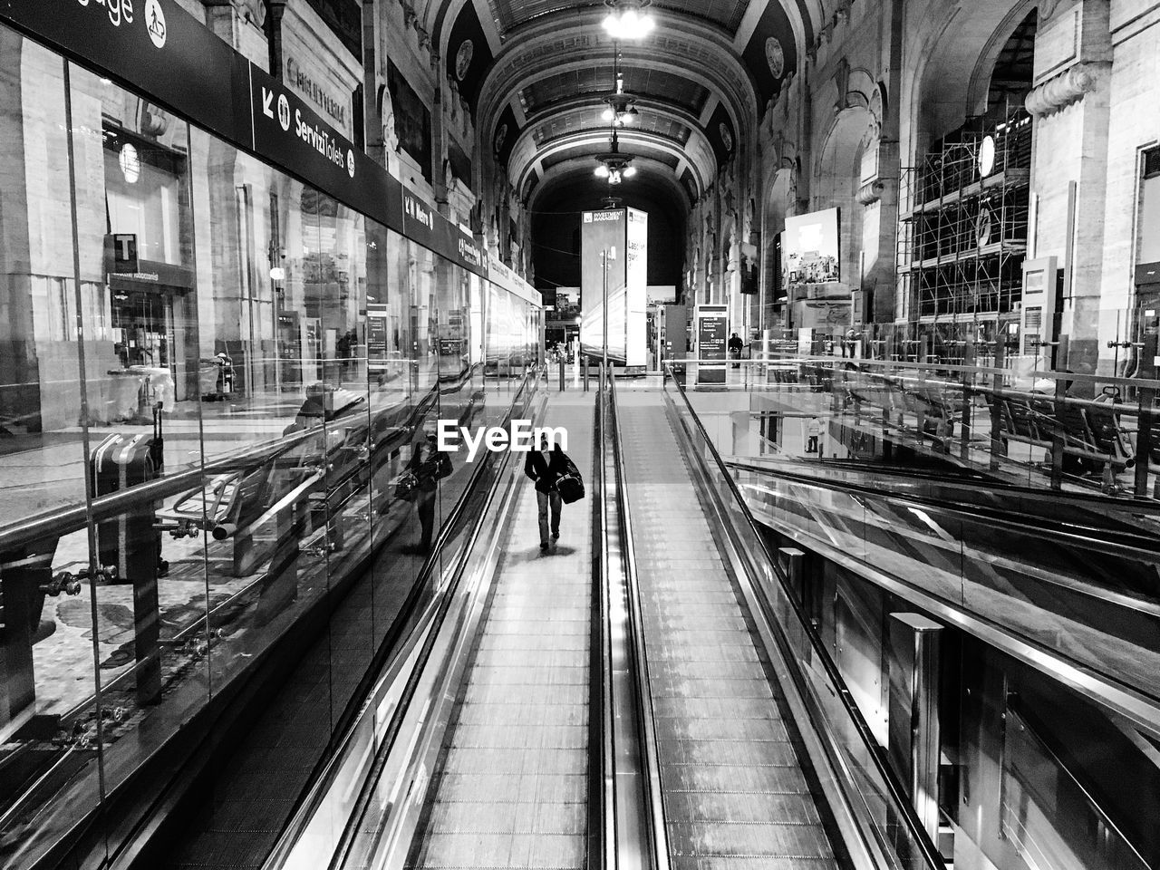 Man walking on moving walkway at subway station