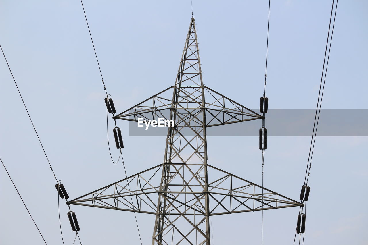 Low angle view of electricity pylon against clear sky