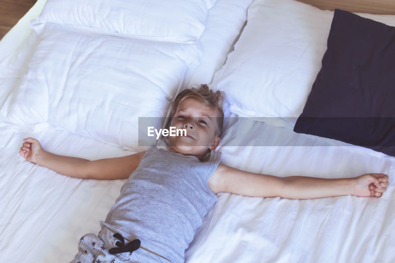 High angle view of boy lying on bed at home