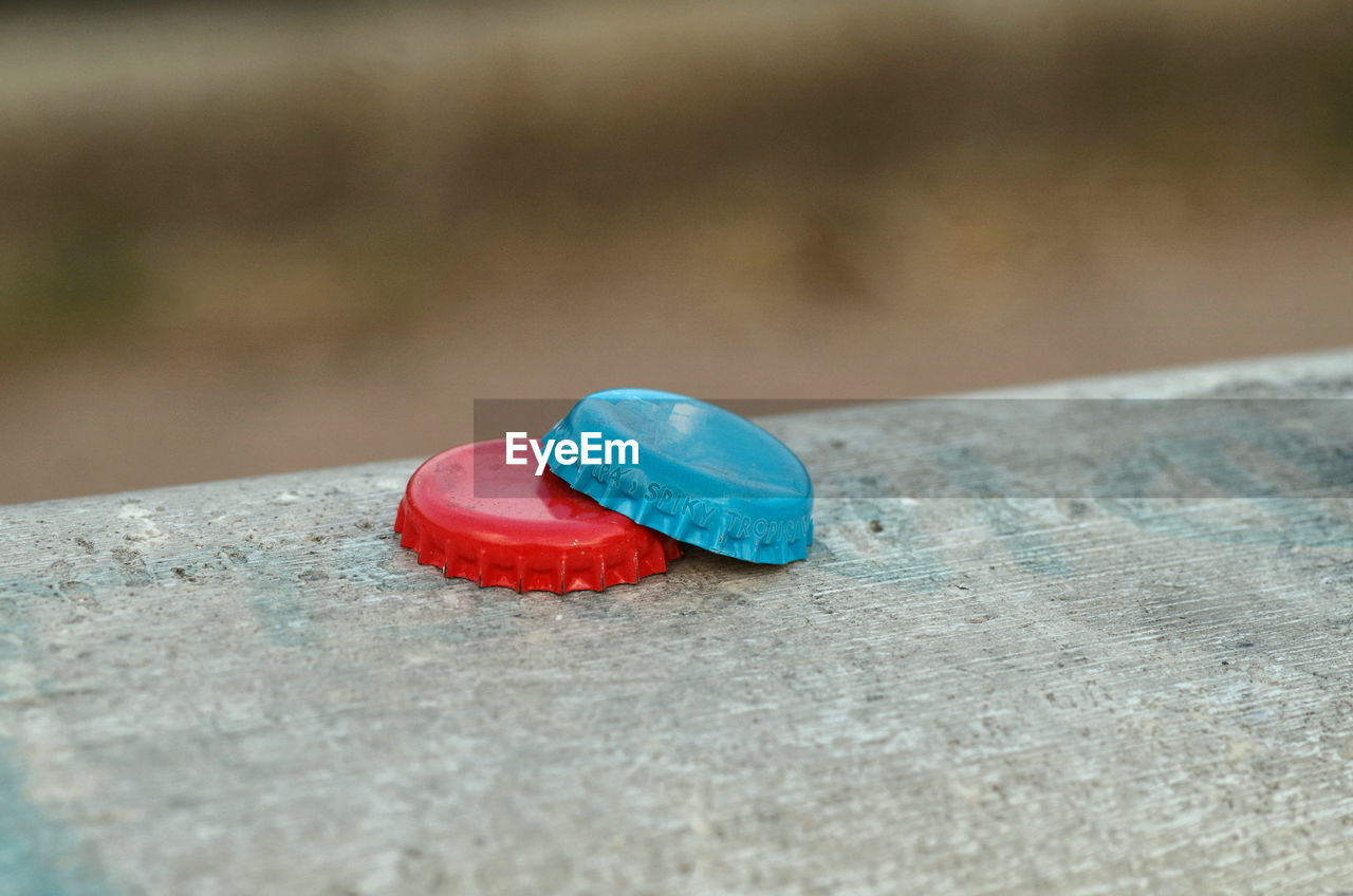 Two colored bottle caps on the wall in focus on foreground