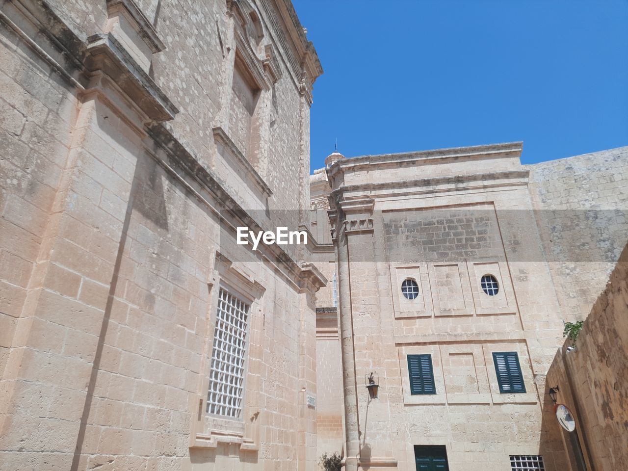 LOW ANGLE VIEW OF BUILDING AGAINST BLUE SKY