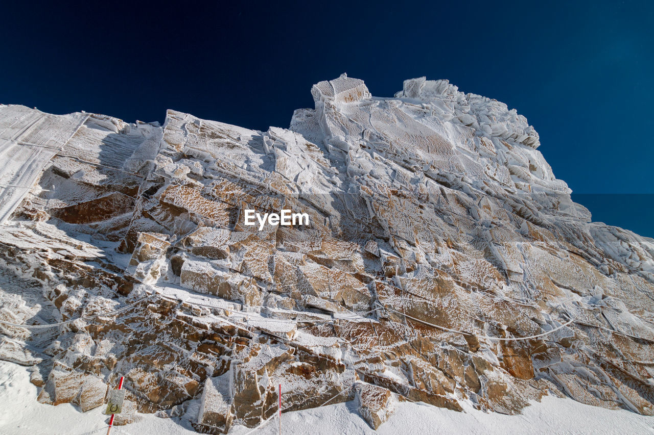 Low angle view of snowcapped mountain against sky