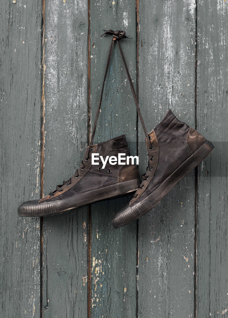 Close-up of shoes hanging on wooden wall