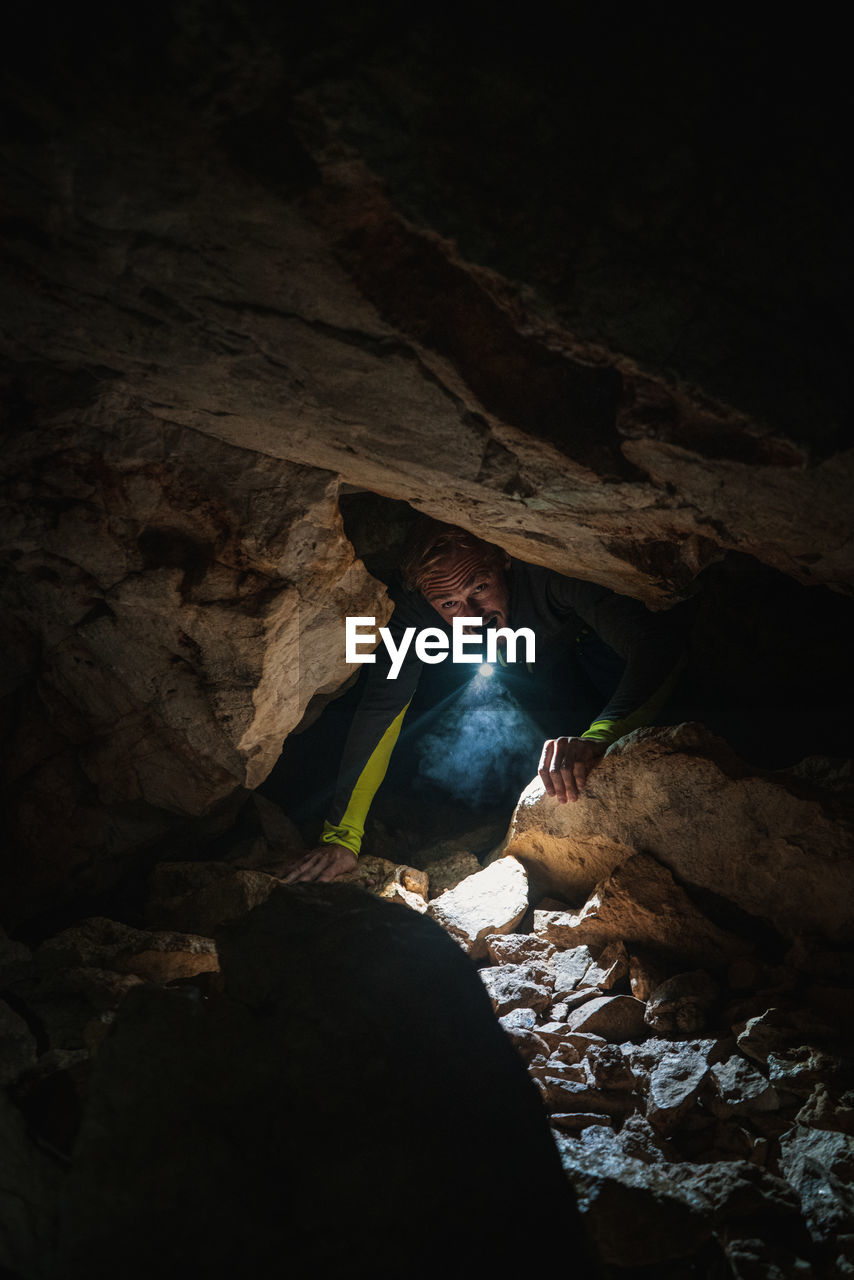 Man with flashlight exploring in cave