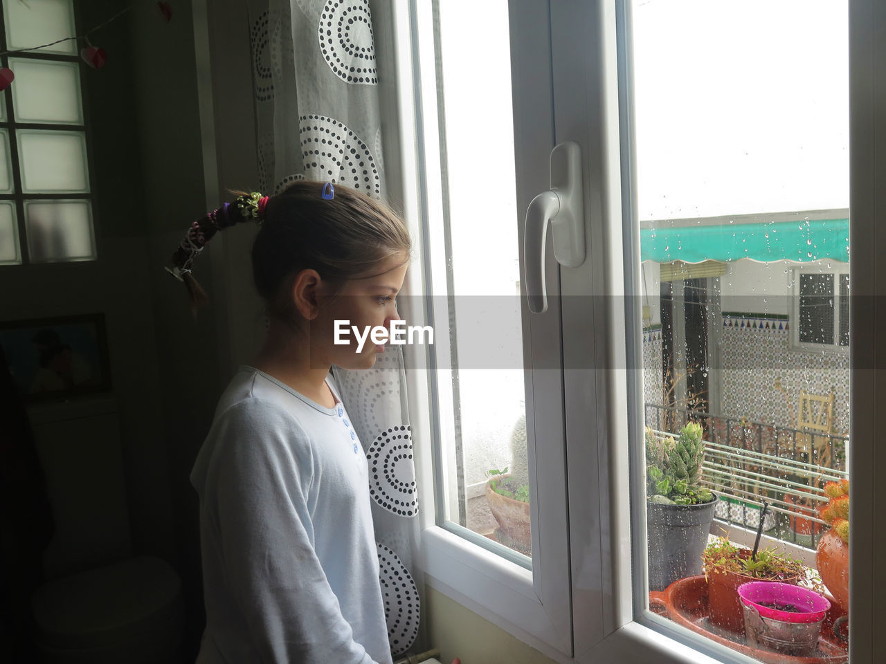 Girl looking out the window on a rainy day