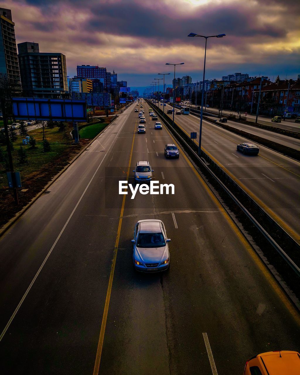 CARS ON ROAD IN CITY AGAINST SKY