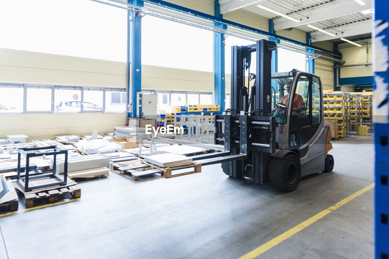 Man on forklift in factory warehouse