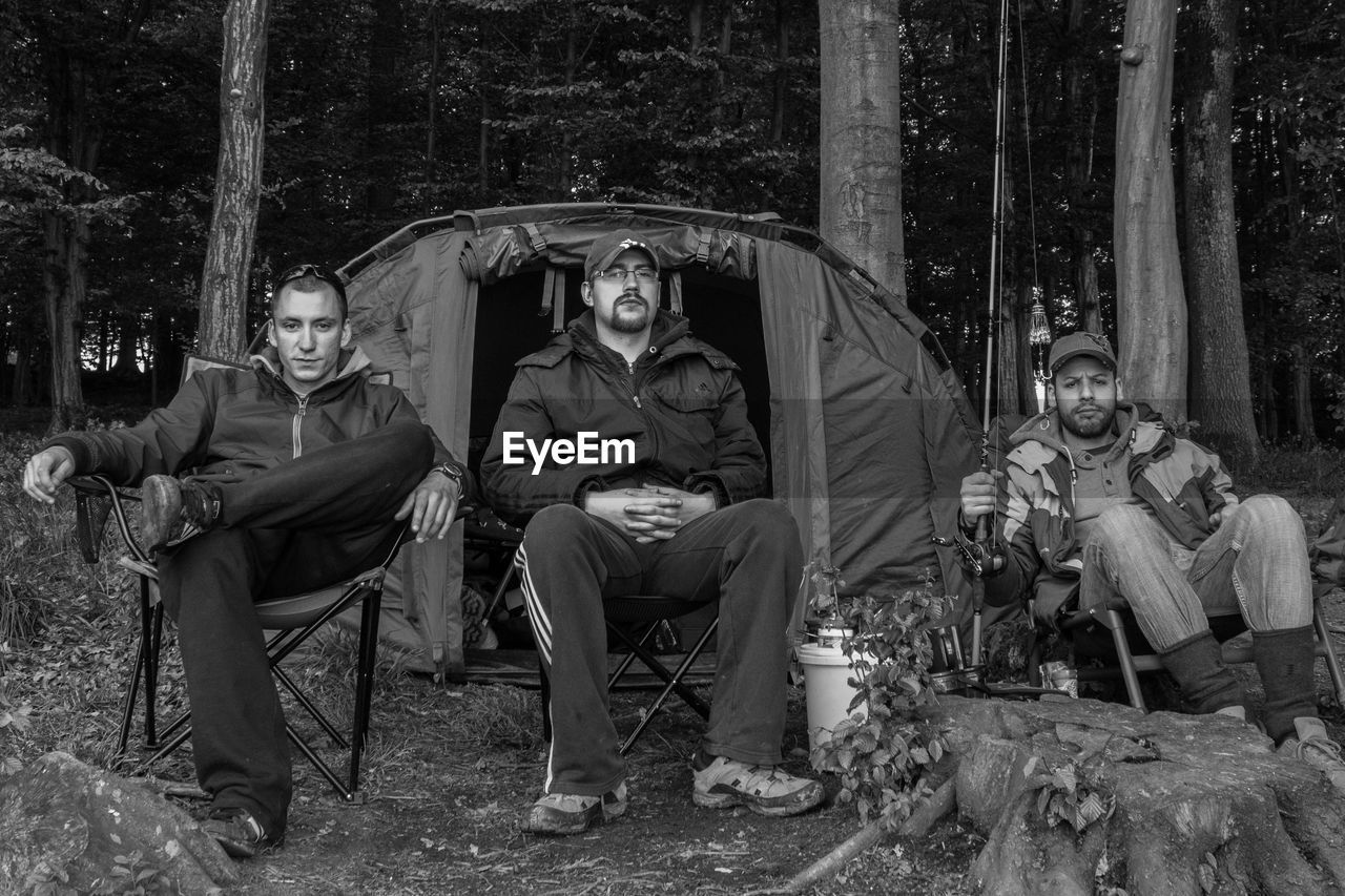 Portrait of friends camping in forest
