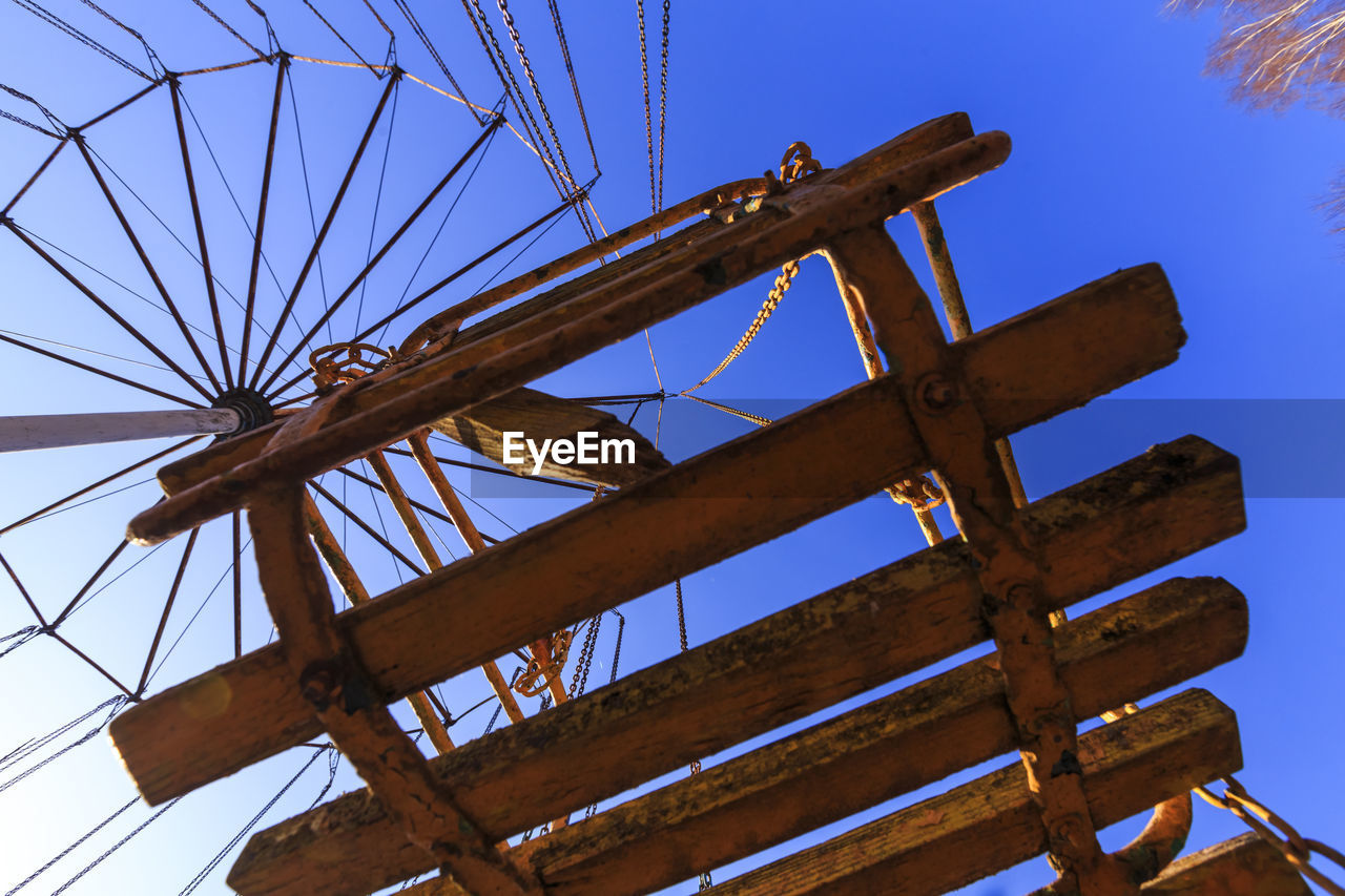 LOW ANGLE VIEW OF METALLIC STRUCTURE AGAINST BLUE SKY