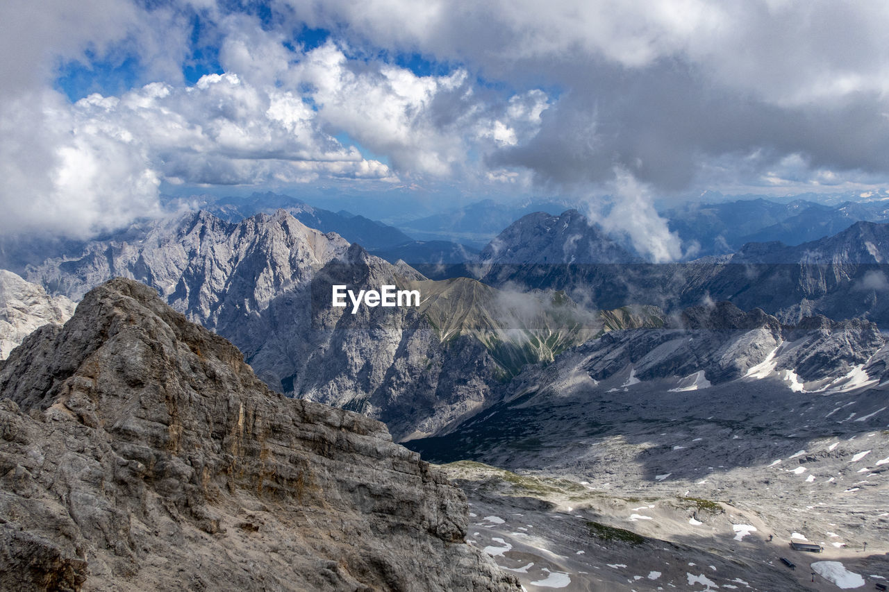 Scenic view of snowcapped mountains against cloudy sky