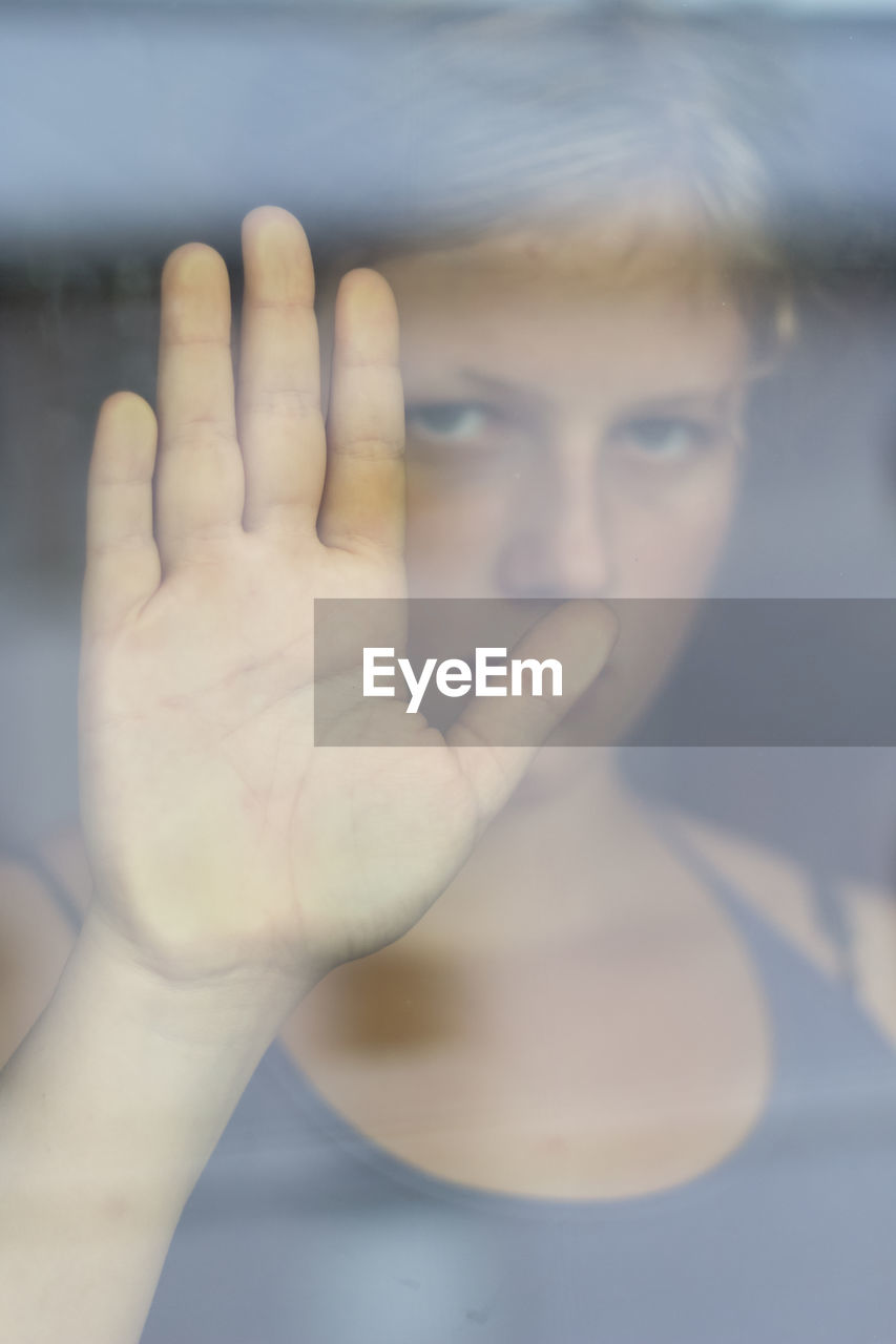 Close-up of girl's hand on glass