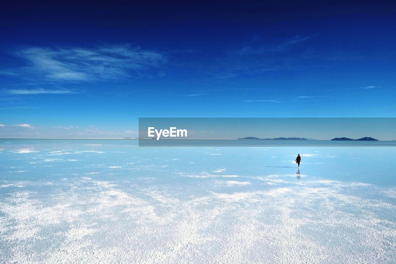 Distant view of person walking on beach