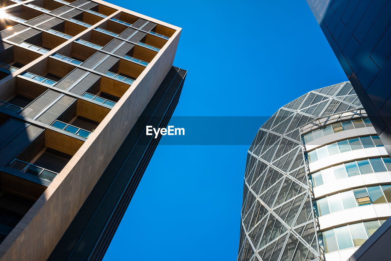 LOW ANGLE VIEW OF MODERN BUILDING AGAINST BLUE SKY