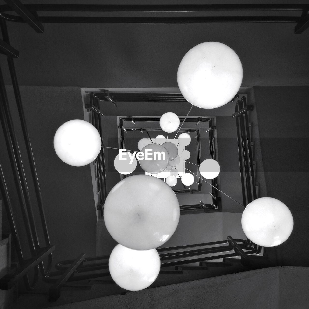 Directly below shot of lanterns hanging amidst spiral steps and staircases