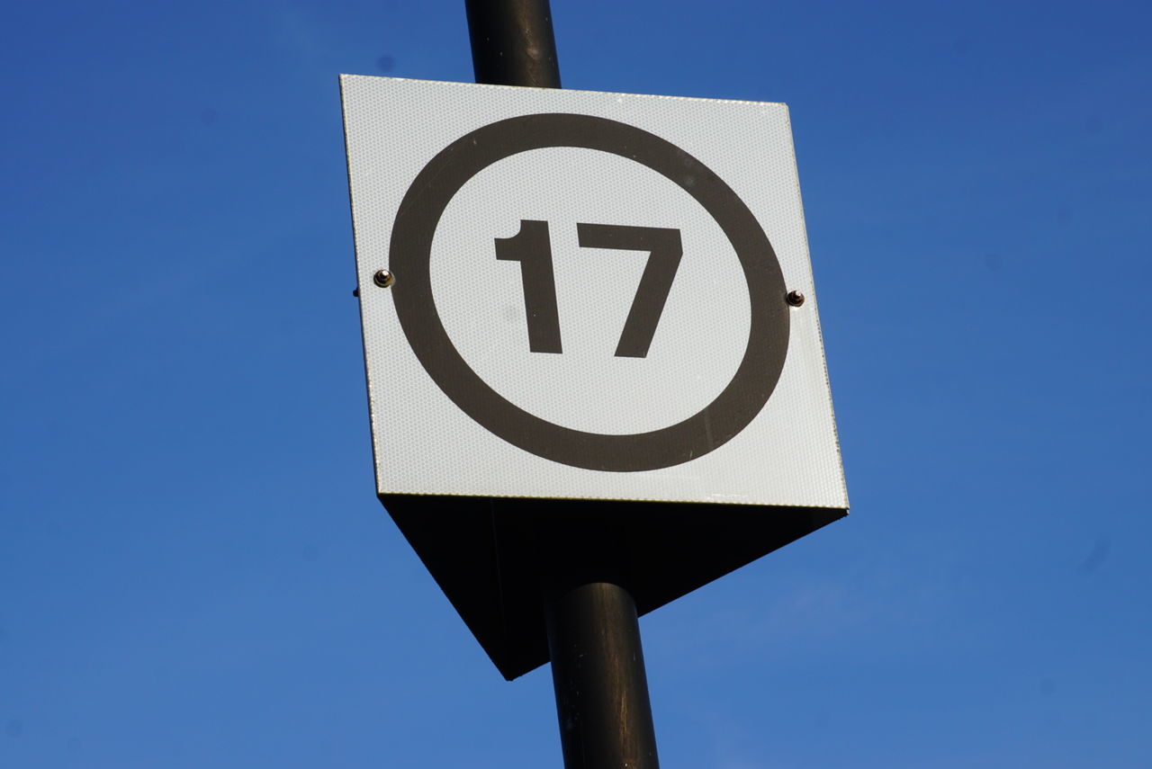 Low angle view of number sign on pole