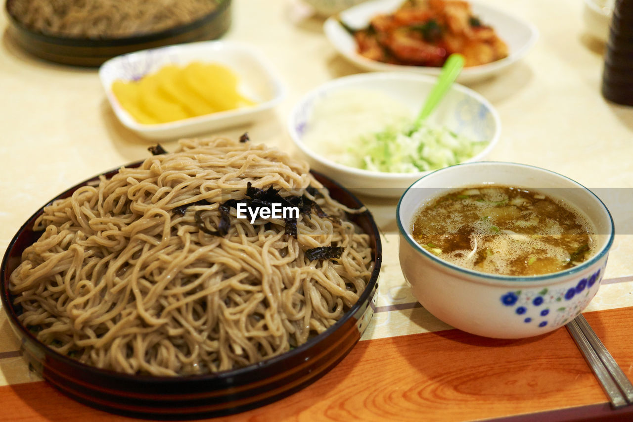 High angle view of noodles and soup served on table