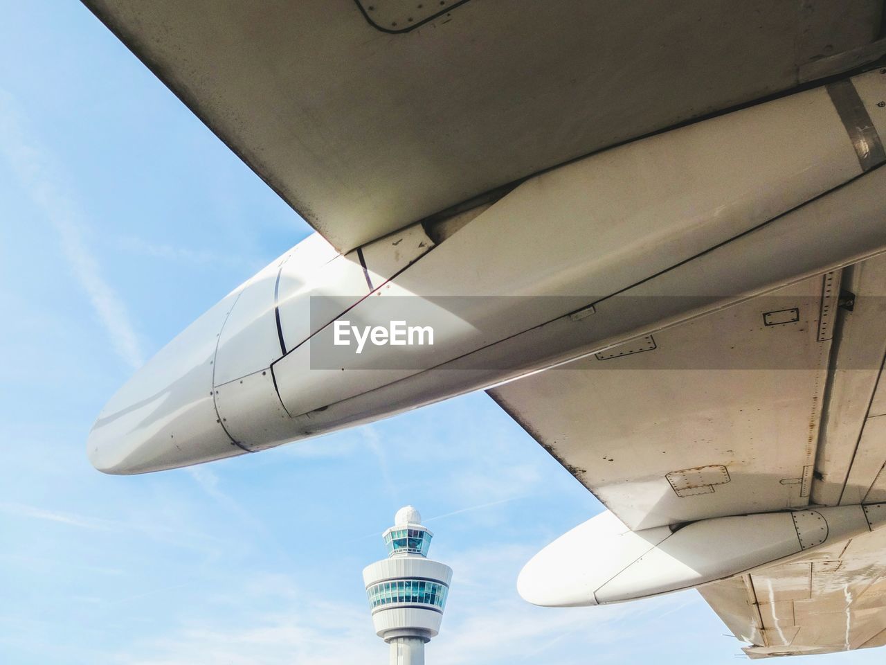 Cropped image of airplane against control tower