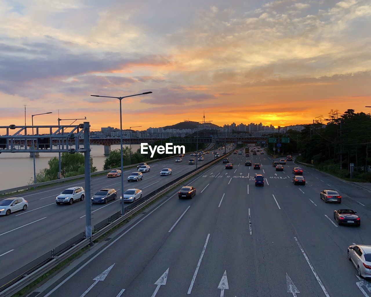 Cars on road against sky during sunset