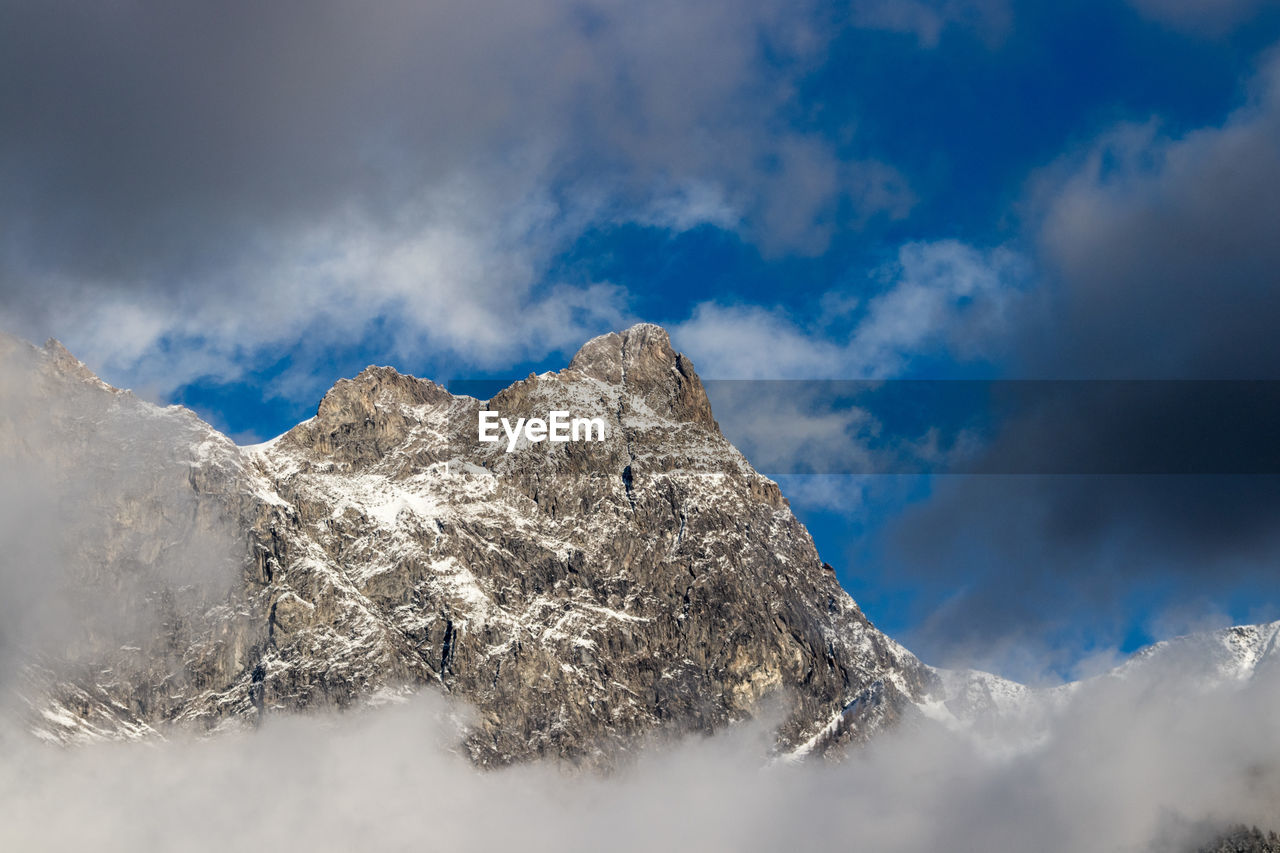 Low angle view of snowcapped mountain against sky