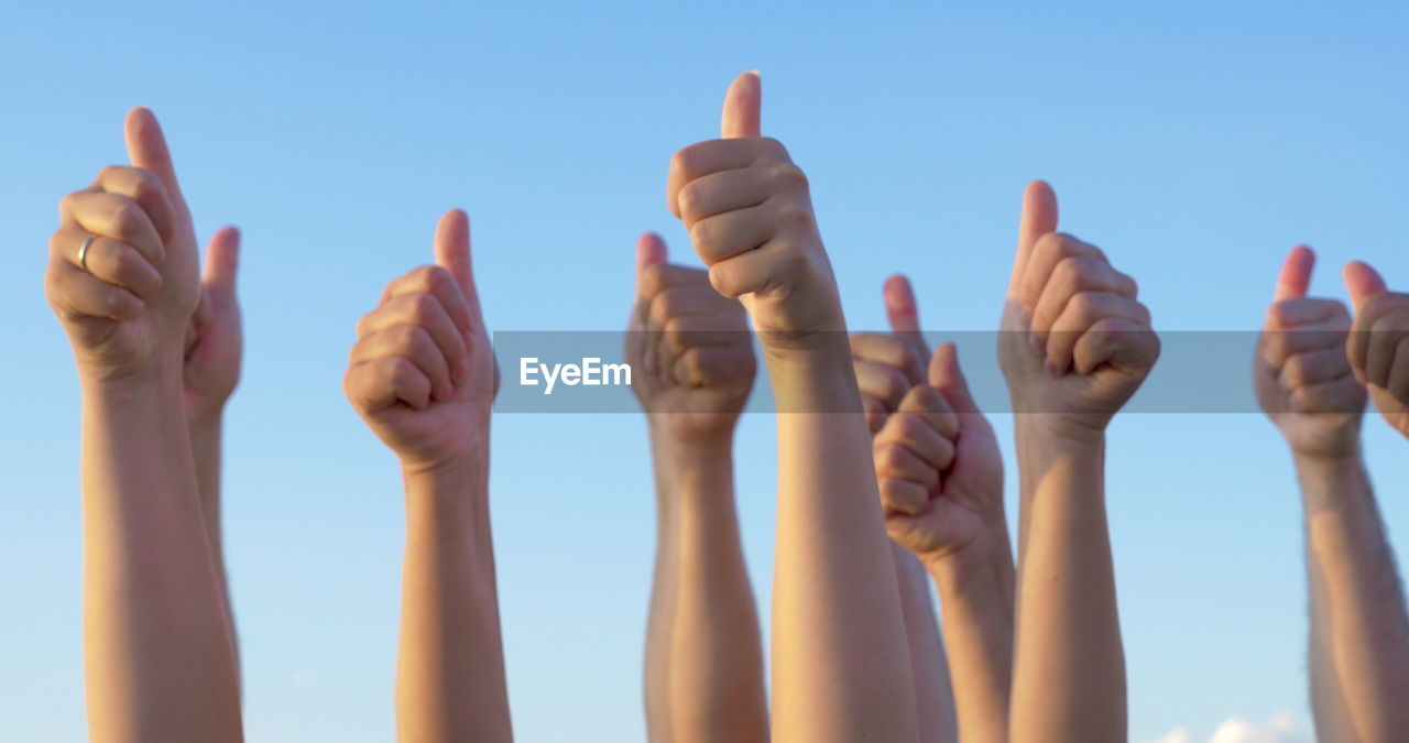 Low angle view of hands against sky