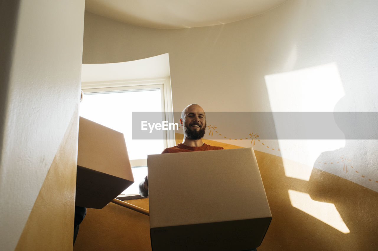 Man carrying cardboard box at staircase