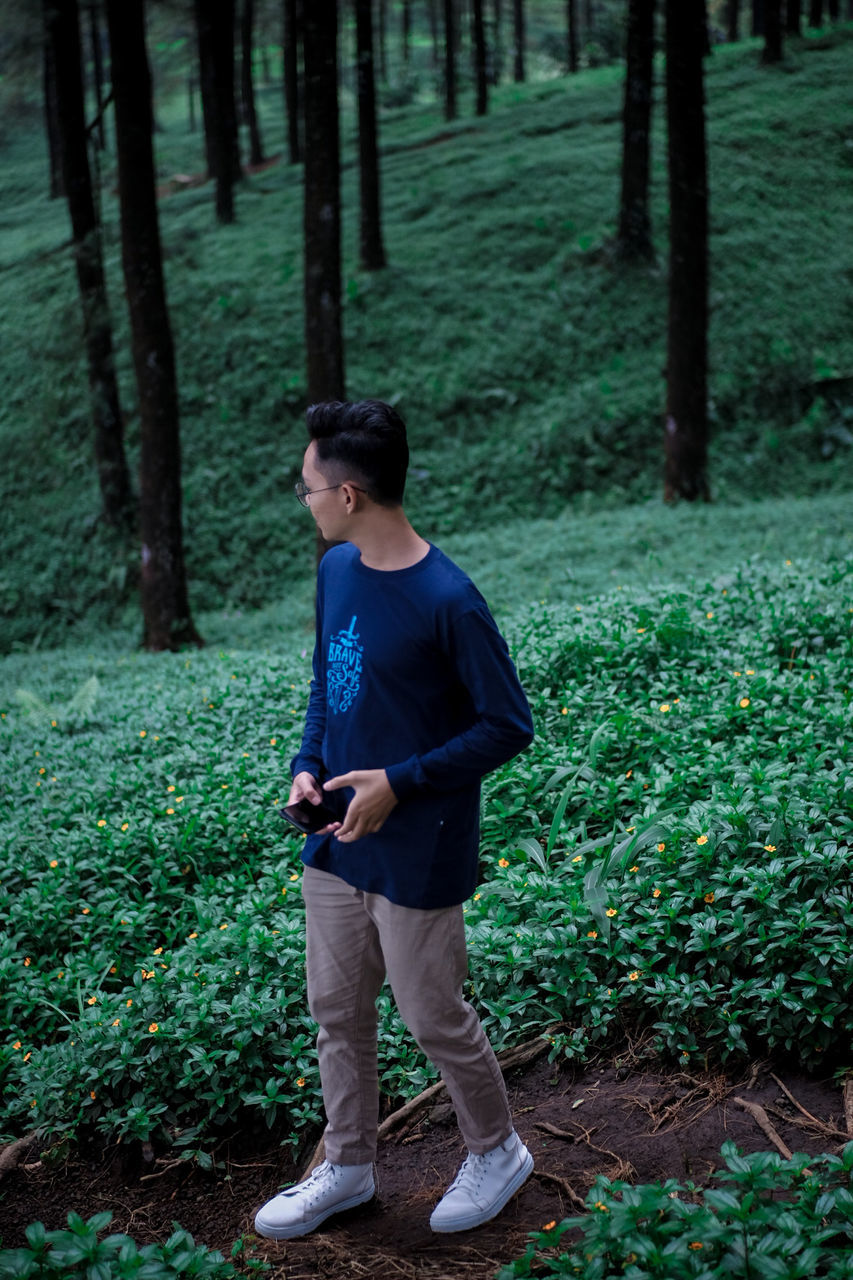 Man standing against trees and plants in forest 3