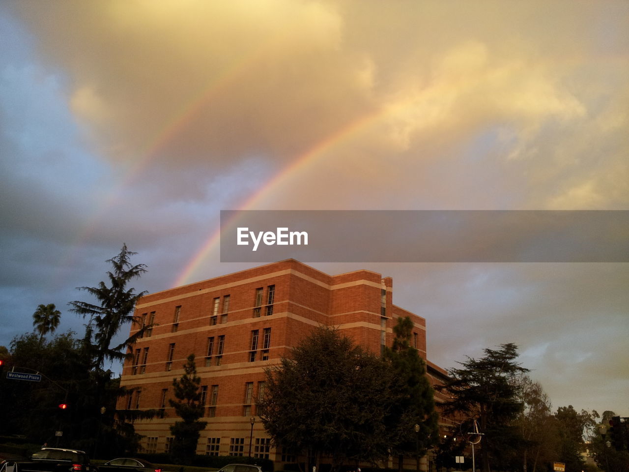 LOW ANGLE VIEW OF RAINBOW AGAINST CLOUDY SKY