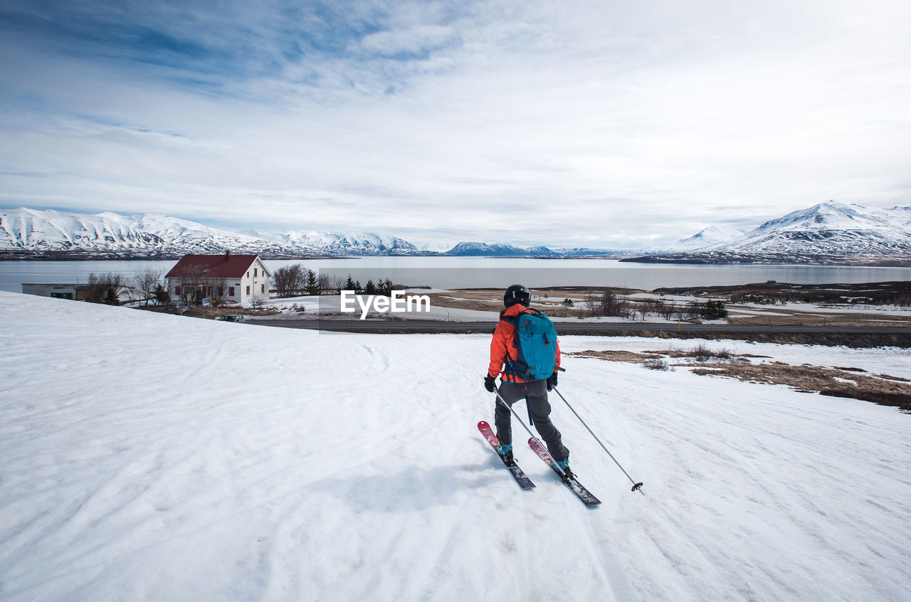 Woman skiing towards the ocean in iceland